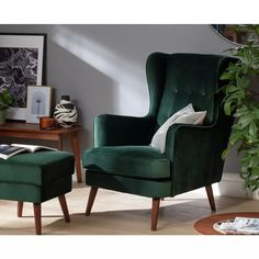 a green chair and footstool in a room with a mirror on the wall