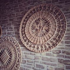 two wicker baskets hanging on a brick wall