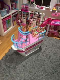 two girls are riding on a pink boat in a play room with other toys and accessories