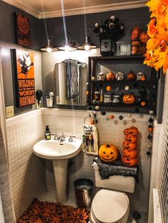 a bathroom decorated for halloween with pumpkins and decorations