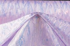 a purple and blue fabric with metallic designs on it's edges, folded in half