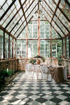 the inside of a greenhouse with tables and chairs