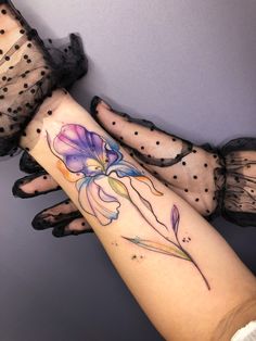 a woman's arm with flowers on it and polka dot net stockings behind her