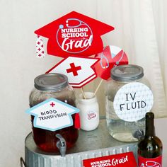 a table topped with mason jars filled with liquid and paper graduation caps on top of each jar