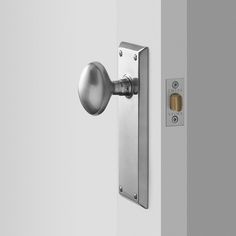 an open door with a brass handle and knob on the side of it, in front of a white wall