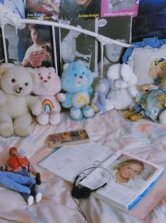 there are many stuffed animals on the bed with books and magazines next to each other