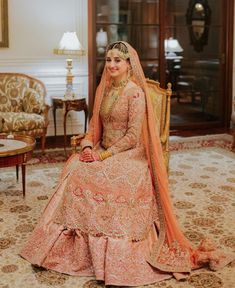 a woman sitting on top of a chair wearing a wedding dress and holding a bouquet