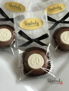 four chocolates wrapped in cellophane and tied with black ribbon