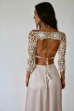 the back of a woman wearing a white dress with crochet detailing on it