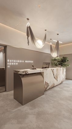 an office lobby with marble counter tops and hanging lights