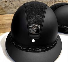 two black helmets sitting on top of a white table