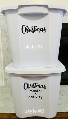 two white plastic containers with christmas style labels on the top and bottom, sitting in front of a fireplace