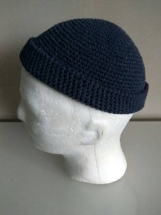 a white mannequin head wearing a blue knitted hat