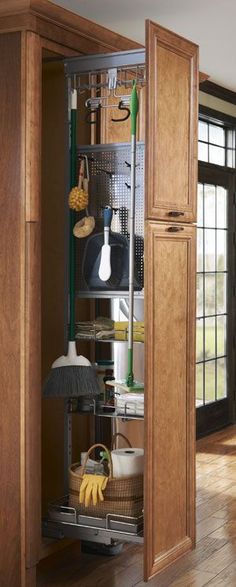 an open pantry door in a kitchen with wooden floors and walls, filled with utensils