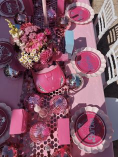 the table is set with pink and purple decorations