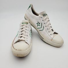 This product is a vintage pair of Converse Pro All Star Archive Leather Sneakers in white with green accents. They are a limited edition release from the 1970s, featuring a low top silhouette with a lace-up closure. The shoes are made of leather with a fabric lining and insole, and have a standard width. They are unisex and come in US and UK size 9.5, and EU size 43. The sneakers are suitable for walking and skateboarding, and are perfect for activewear or casual occasi 70s Converse, Mens Tie, Green Sneakers, Green Accents, Tie Shoes, Converse All Star, Shoes Trainers, Converse Shoes, Sneakers White