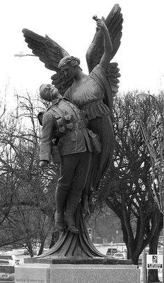 a statue of a man with an eagle on his arm and another person standing next to it