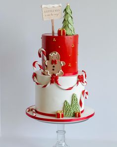 a three tiered christmas cake decorated with gingerbreads, candy canes and decorations