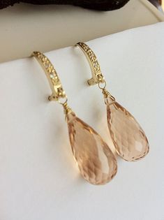 Morganite Earrings. Peach Morganite. Morganite dangles. Pink Orange. Gold Pave Leverbacks. Luxury jewelry. Morganite jewelry. Statement earrings. These beautiful earrings are handcrafted with stunning peach Morganite (Beryl) gemstones in a beautiful faceted briolette shape and gold vermail Pave leverbacks. Simple yet very elegant statement. Gorgeous, elongated teardrops were wire wrapped with gold-fill wire and finished with diamond looking earwires. Choose your stones: 36 carats, each is 31x10. Elegant Peach Dangle Earrings, Elegant Handmade Peach Jewelry, Peach Dangle Jewelry For Wedding, Morganite Jewelry, Morganite Earrings, Orange Gem, Earrings Luxury, Peach Morganite, Studio City