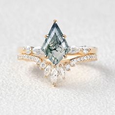 an engagement ring with a green and white diamond in the center, surrounded by smaller diamonds