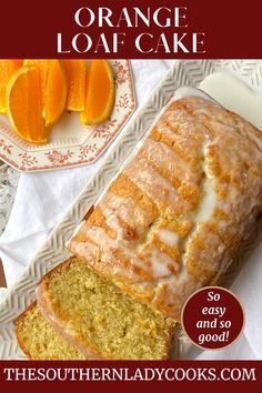 a loaf of orange bread on a plate next to sliced oranges