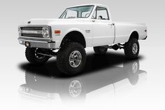 a white pickup truck parked on top of a reflective surface