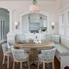 a dining room table surrounded by blue and white chairs