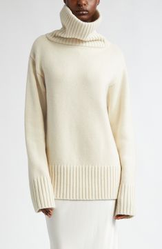 A dramatically oversized turtleneck brings scarf-inspired warmth to this roomy sweater knit from pure cashmere in a pale ivory hue. 27" length (size Large) Turtleneck Long sleeves Dropped shoulders Ribbed cuffs and hem 100% cashmere Dry clean Imported Designer Clothing Cozy Cream Cashmere Sweater, Classic White Funnel Neck Sweater, Cream Turtleneck With Ribbed Cuffs, Luxury White Winter Sweater, Cream Cashmere Turtleneck Sweater, Cream Knit Sweater With Funnel Neck, Luxury White Wool Sweater, Cream Funnel Neck Knit Sweater, Elegant Oversized Turtleneck Sweater