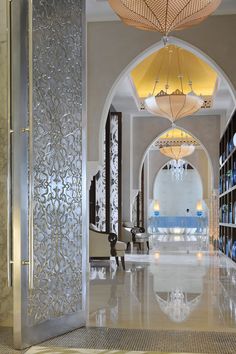 the inside of a hotel lobby with an arched doorway and chandelier hanging from the ceiling