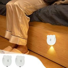 a person sitting on top of a bed next to two lights