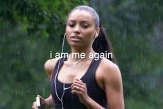 a woman running in the rain with headphones on her ears and an earbud