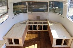 the inside of a camper with wooden tables and benches on it's side