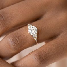 a woman's hand with a diamond ring on top of her finger and an engagement band