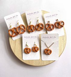 Introducing our Handmade Soft Pretzel Earrings, a delightful addition to your collection. Crafted from clay, each pair features lifelike pretzels with intricate detailing and a sprinkle of salt. Lightweight and comfortable, they're perfect for expressing your love for snacks all day long. Whether you're a foodie or simply seeking a fun accessory, these earrings are sure to charm. Ideal for gifting, they're crafted with care and designed to last. These are the perfect earrings for Oktoberfest! Earring Clay, Geeky Jewellery, Soft Pretzel, Birthday Traditions, Clay Things, Ring Inspo, Soft Pretzels, Earring Ideas, Handmade Miniatures