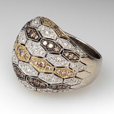 This substantial Sonia B. ring features a domed pierced design and is accented with sixty-eight (68), bead set, round brilliant cut diamonds and fifty-nine (59), bead set, round brilliant cut champagne colored diamonds. The ring measures 21.6mm at the top, rises 8.5mm above the finger, tapering to 6.8mm wide and 1.6mm thick at the base of the shank. The ring is size 8 and resizing is not recommended. Luxury Multi-stone Diamond Cluster Ring, Luxury Multi-stone Cluster Diamond Ring, Luxury Multi-stone Cubic Zirconia Diamond Ring, Luxury Cubic Zirconia Multi-stone Diamond Ring, Anniversary Multi-stone Dome Ring In Fine Jewelry Style, Fine Jewelry Multi-stone Dome Ring, Luxury Rose Cut Diamond Dome Ring For Anniversary, Luxury Dome Ring With Rose Cut Diamonds For Anniversary, Luxury White Dome Ring With Brilliant Cut