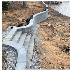 an image of a retaining wall being built on the side of a river bank with rocks and gravel around it