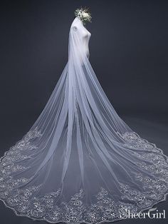 the back of a wedding veil with flowers on it, in front of a dark background