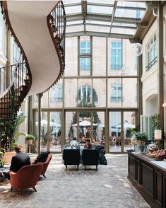 a large open living room with stairs leading to the second floor and two people sitting on couches