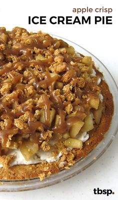 an ice cream pie with caramel topping in a glass dish on a white table