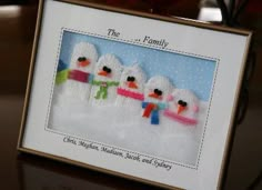 there is a picture frame with three snowmen on it and the words, the family