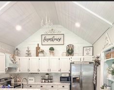 a kitchen with white cabinets and an island in front of the stove, refrigerator and sink