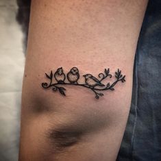 a tattoo on the leg of a woman with three birds sitting on a tree branch