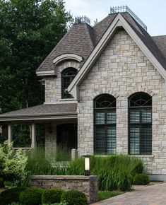 a brick house with two large windows on the front