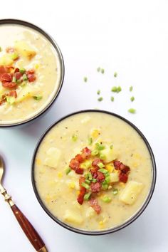 two bowls filled with soup on top of a white table