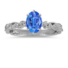 an oval blue sapphire and diamond ring set in 18k white gold with diamonds on the band