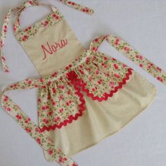 a child's apron and apron set with name on the front, red flowers