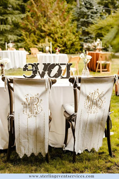 the chairs are covered with white linens and decorated with mr and mrs's signs