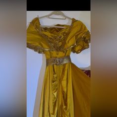 a yellow dress is hanging on a hanger