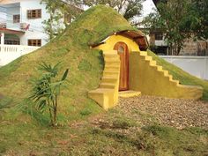 a house made out of grass with stairs leading up to it