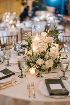 the table is set with candles, flowers and silverware for an elegant wedding reception